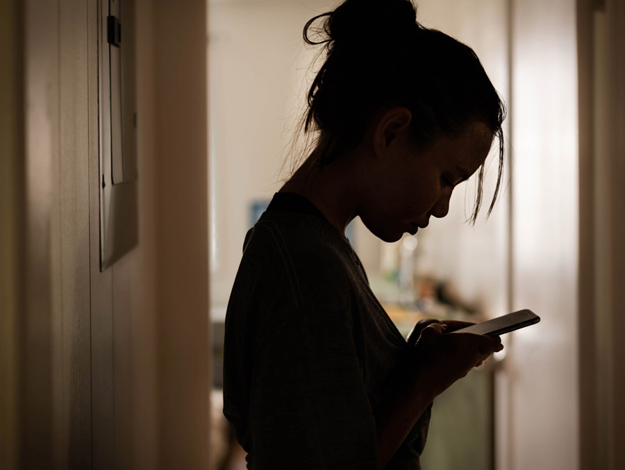 Serious woman looking at her phone at home stressed